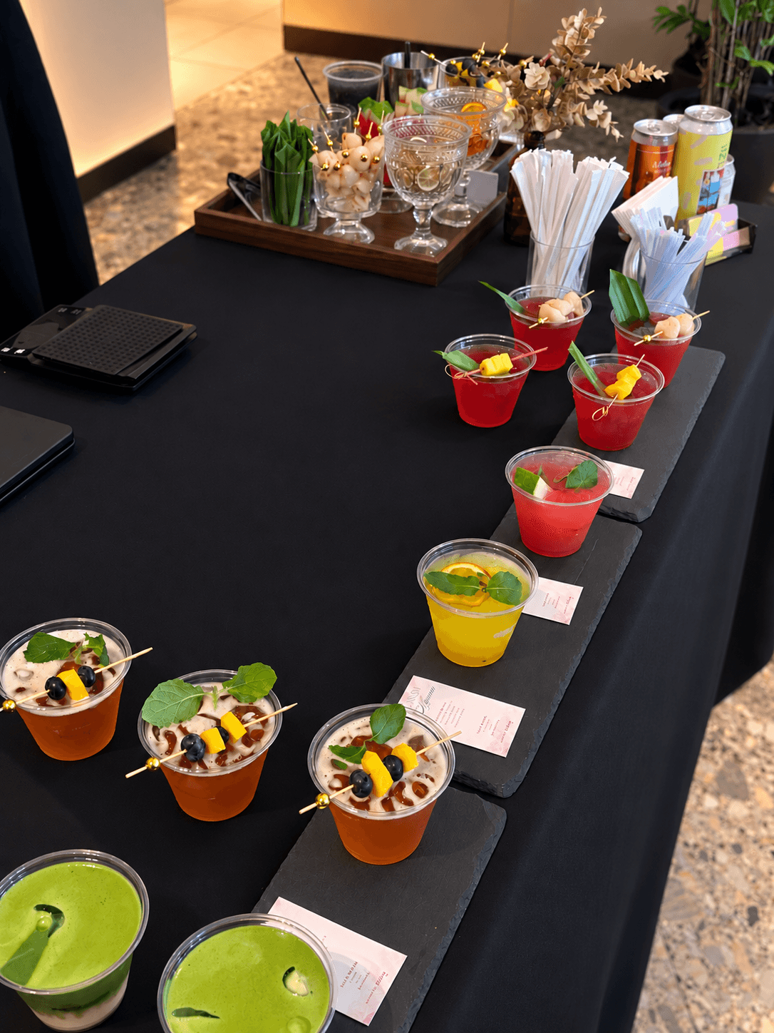 Mocktail drinks arranged diagonally on individual black slate serving boards
